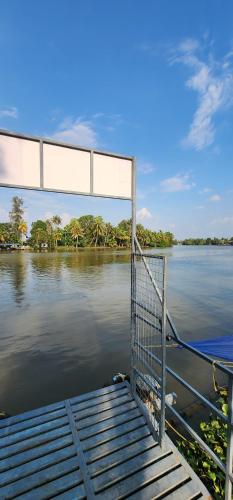 a view of a body of water with a dock at Punerjeni Homes in Alleppey