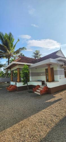 a house with red chairs in front of it at Punerjeni Homes in Alleppey