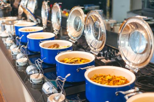 een rij blauwe schalen met eten in bij Hotel Baraquda Heeton Pattaya by Compass Hospitality in Pattaya