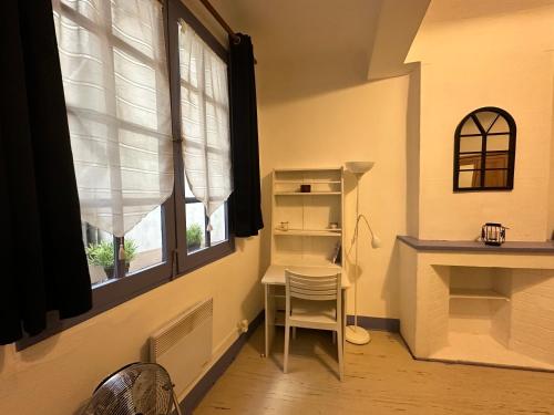une pièce avec une table, une chaise et une fenêtre dans l'établissement Chez Florence - Appartement T2 d au cœur du centre ville historique - Proche Cardeurs et Mairie, à Aix-en-Provence