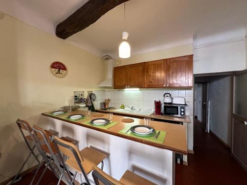 - une cuisine avec un comptoir avec des chaises et un four micro-ondes dans l'établissement Chez Florence - Appartement T2 d au cœur du centre ville historique - Proche Cardeurs et Mairie, à Aix-en-Provence