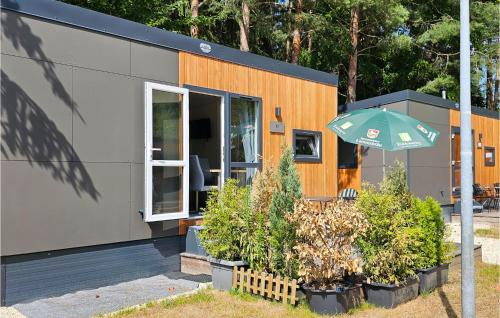a small house with an umbrella in front of it at Waldcamping Am Brombachsee in Pleinfeld
