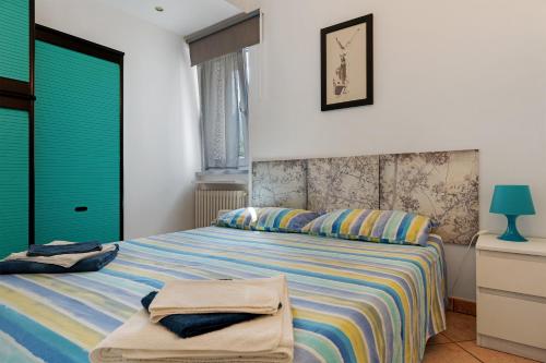 a bedroom with a bed with a striped bedspread at Ciclamino Superior Otto in San Lorenzo in Banale