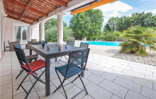a table and chairs on a patio with a pool at Nice Home In Saint-Cézaire-Sur-Siagne in Saint-Cézaire-sur-Siagne