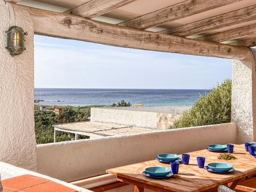 a table with blue dishes on a balcony with the beach at Villa Adea in Santa Teresa Gallura