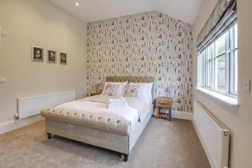 a bedroom with a bed and a large window at The Kings Arms Rooms in Saint Osyth