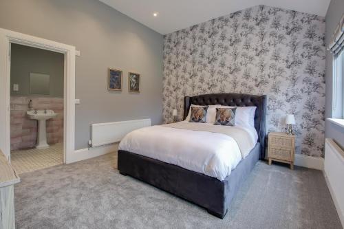 a bedroom with a large bed and a bathroom at The Kings Arms Rooms in Saint Osyth