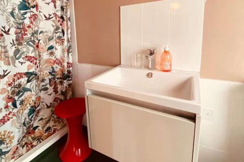 a bathroom with a white sink and a shower curtain at The Dairy - Seaside Couples Escape in Whitstable in Whitstable