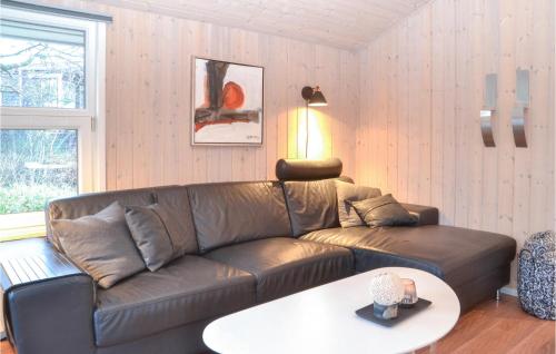 a living room with a leather couch and a table at Holiday Home Gøgevej Henne I in Henne Strand