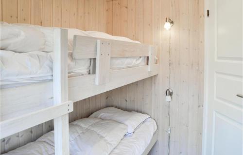 two bunk beds in a room with wooden walls at Holiday Home Gøgevej Henne I in Henne Strand