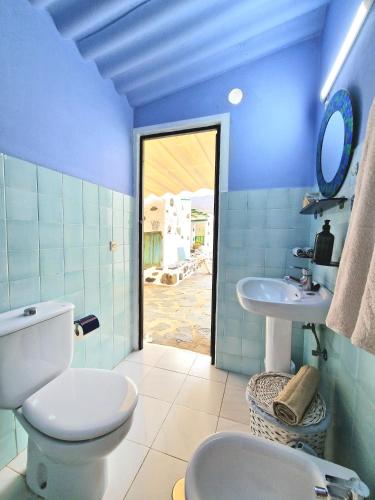 a blue bathroom with a toilet and a sink at Small cozy house Susana in Mogán