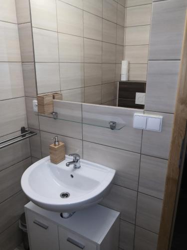 une salle de bain avec un lavabo blanc et un miroir dans l'établissement Ubytování v soukromí Klima, à Český Krumlov