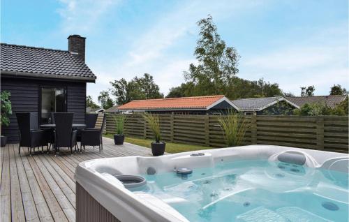 a hot tub on a patio with a table and chairs at Lovely Home In Juelsminde With Wifi in Juelsminde
