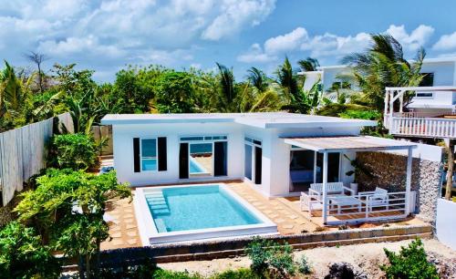 a small house with a swimming pool in front of it at Villa Azurina in Fumba