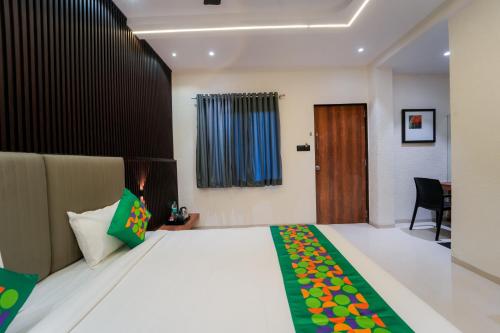 a bedroom with a bed and a desk and a chair at Treebo Iceberg in Mahabaleshwar