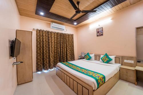 a bedroom with a large bed and a television at Treebo Iceberg in Mahabaleshwar