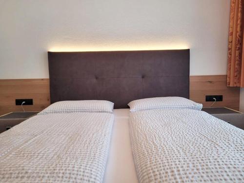 ナウダースにあるValdafur Suitesのベッドルーム1室(ベッド2台、茶色のヘッドボード付)