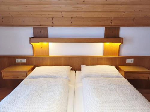 two beds in a room with wooden walls at Valdafur Suites in Nauders