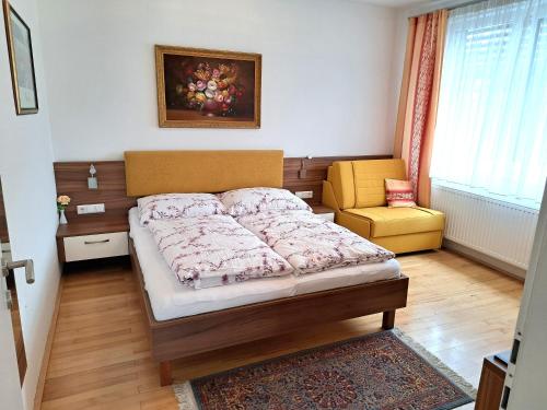 a small bedroom with a bed and a chair at Ferienwohnungen Oliver Bayer in Bad Schallerbach