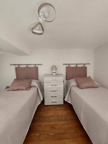 two beds sitting next to each other in a bedroom at Tarantè Apartment in Naples