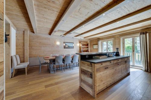 une cuisine et une salle à manger avec une table et des chaises dans l'établissement CHALET AROLAY, à Le Fornet