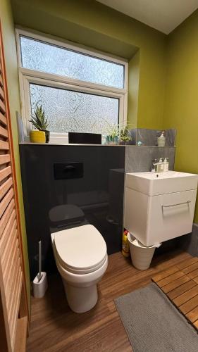 une salle de bain avec des toilettes blanches et un lavabo dans l'établissement 8 Riversdale King Size Room, à Manchester