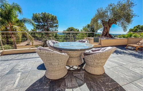a patio with a glass table and chairs at Lovely Home In Cuers With Kitchen in Cuers