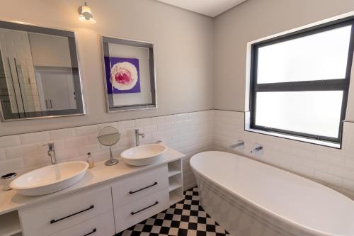 a bathroom with two sinks and a bath tub at Waveren's Nest in Cape Town