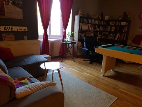 a living room with a couch and a pool table at La Petite Maison du Gardien in Sainte-Agnès