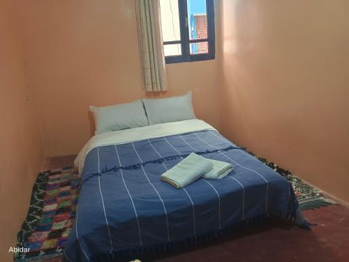 a blue bed with two pillows on top of it at Wave Apartments in Taghazout