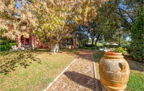 a large vase sitting in the grass in front of a house at Awesome Home In Fucecchio in Fucecchio
