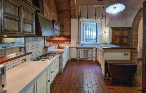 a large kitchen with white cabinets and a brick floor at Awesome Home In Fucecchio in Fucecchio