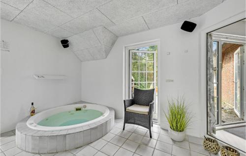 a large bathroom with a tub in a room at Stunning Home In Ringkøbing With Sauna in Søndervig