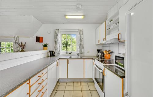 a kitchen with white cabinets and a window at Stunning Home In Ringkøbing With Sauna in Søndervig