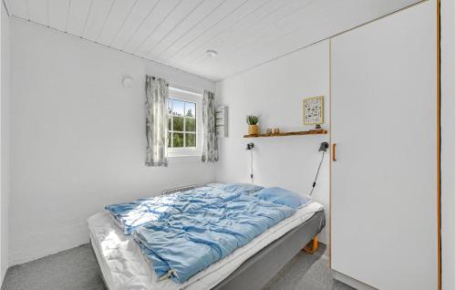 a bed in a white room with a window at Stunning Home In Ringkøbing With Sauna in Søndervig