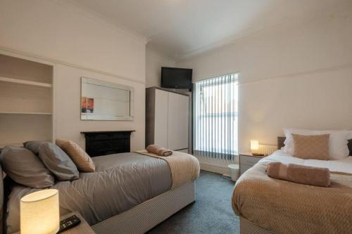 ein Wohnzimmer mit zwei Betten und einer Couch in der Unterkunft CJP - Lovely 2-bed house in Hull Centre, Parking in Hull