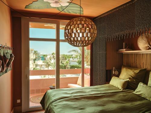 a bedroom with a bed and a large window at Bikini Island & Mountain Hotel Es Trenc -Adults only- in Colonia Sant Jordi