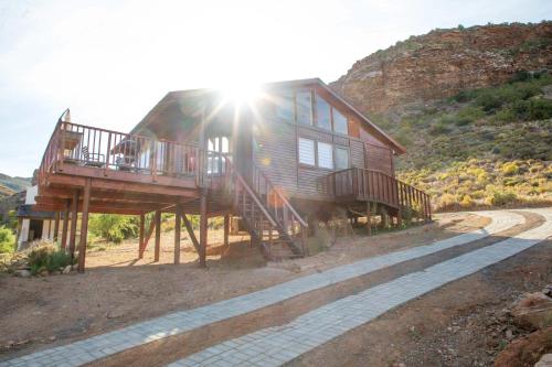 a house with a deck on the side of a hill at Bushman Valley in Prince Albert