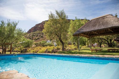 a swimming pool with a gazebo and a picnic table at Bushman Valley in Prince Albert