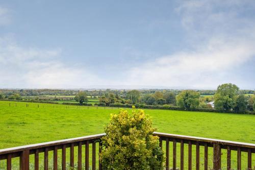 a wooden deck with a view of a green field at Beech Lodge, Ballindrum R14RX60 in Athy