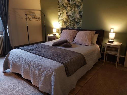 a bedroom with a large bed with two lamps at Le Chateau in Sainte-Agnès