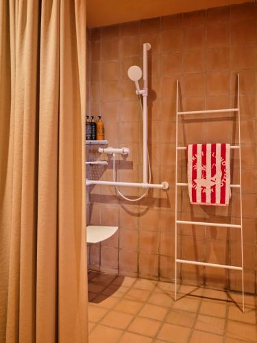a shower with a shower curtain in a bathroom at Bikini Island & Mountain Hotel Es Trenc -Adults only- in Colonia Sant Jordi