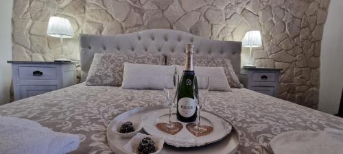 a bed with a bottle of wine and two glasses at La casa di Agnese in Fiuggi