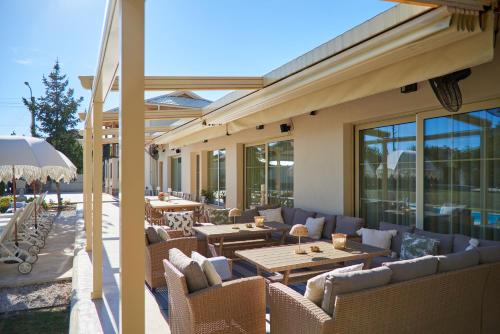 an outdoor patio with couches and tables and windows at Villa Alma 1910 Starosel in Starosel