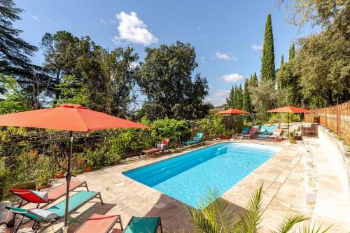 a swimming pool with chairs and umbrellas at Suite Petite -Nice - SPA-JACUZZI - MASSAGE- SAUNA - 4 SAISONS - Piscine Chauffée Toute l'année - POOL VIEW- Heated Pool 800m city centre Nyons in Nyons