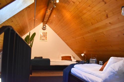 a attic bedroom with two beds and a wooden ceiling at The Building 6 Loft in Spiez