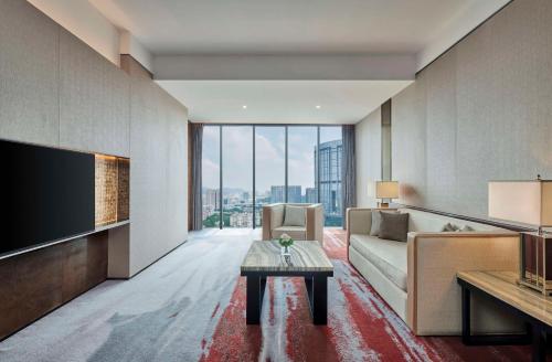 a living room with a couch and a tv at Hilton Guangzhou Tianhe - Free Shuttle Bus and Registration Counter Available during Canton Fair Period in Guangzhou
