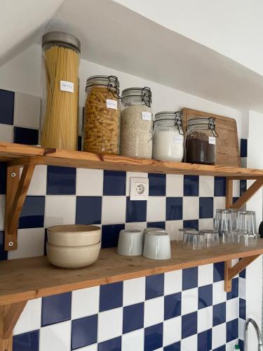une étagère avec bocaux et autres articles de cuisine dans l'établissement Petit appartement parisien, à Paris