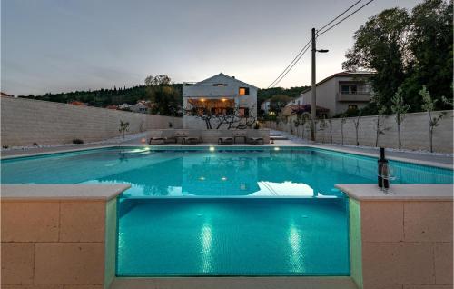 プレコにあるGorgeous Home In Prekoのワインのボトルが置かれた大きな青いプール