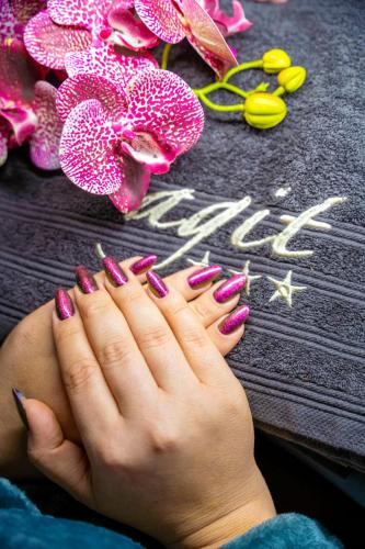 una mujer con uñas rosas y moradas y flores en Hotel Agit Congress&Spa, en Lublin